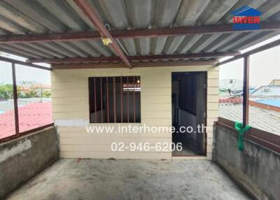 Outdoor balcony area with a small storage room