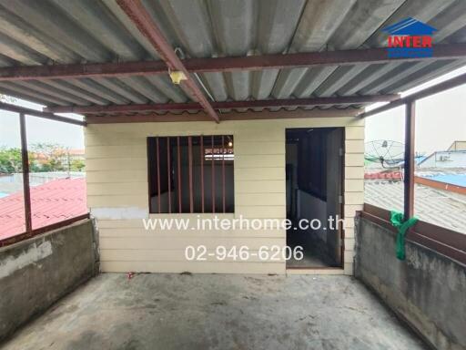 Outdoor balcony area with a small storage room