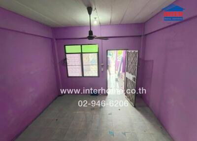 Purple-walled room with tiled floor, ceiling fan, window, and door leading outside.
