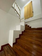 Indoor staircase with wooden steps and yellow curtain