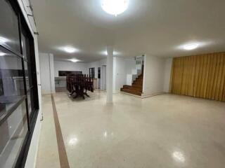 Spacious main living area with dining table, stairs, and bright lighting