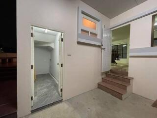 Entryway with open door, stairs, and adjacent bathroom