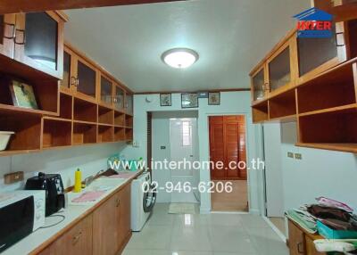 Kitchen with wooden cabinets, appliances, and tiled floor