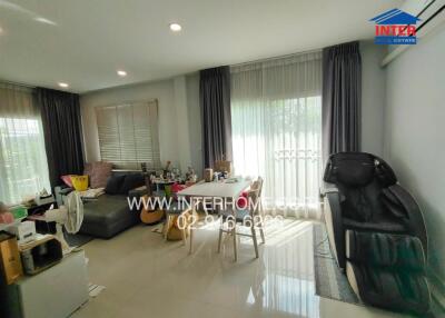 Living room with large windows and dining area