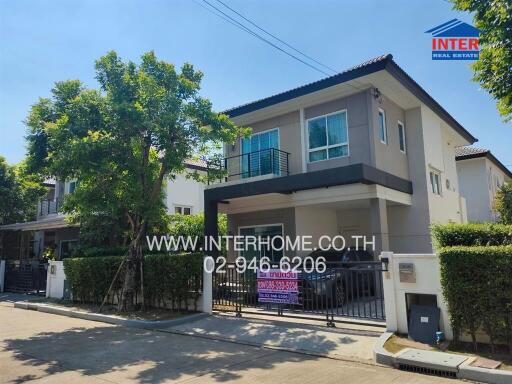 Two-story house with trees and driveway