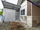 Side view of a residential building with an attached shed and an air conditioning unit