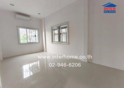 Spacious empty living room with tiled floor and windows with bars
