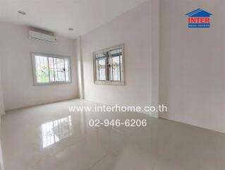 Spacious empty living room with tiled floor and windows with bars