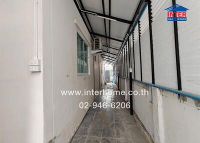Outdoor hallway with tiled flooring and a window