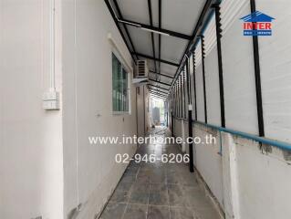 Outdoor hallway with tiled flooring and a window