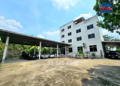 Exterior view of a multi-story building with attached carport