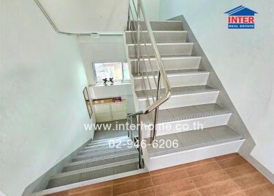 Modern staircase with metal railing and wooden floor