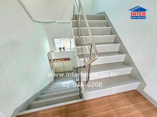 Modern staircase with metal railing and wooden floor