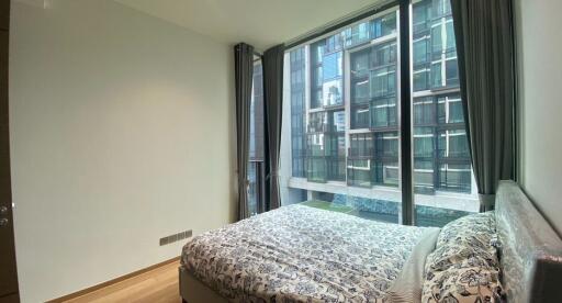 Modern bedroom with large windows and a decorated bed