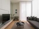 Modern living room with a sofa, TV, coffee table, and large window with curtains.