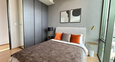 Modern bedroom with large bed, stylish decor, and floor-to-ceiling window