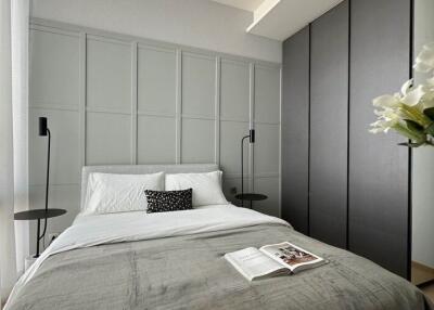 Modern bedroom with a bed, wardrobes, two bedside tables, and a bouquet of flowers