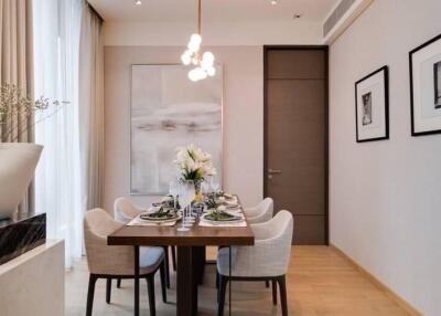 Modern dining room with a stylish table set for six, elegant decor, and contemporary lighting