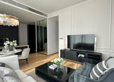 Modern living room with black furnishings and a contemporary chandelier