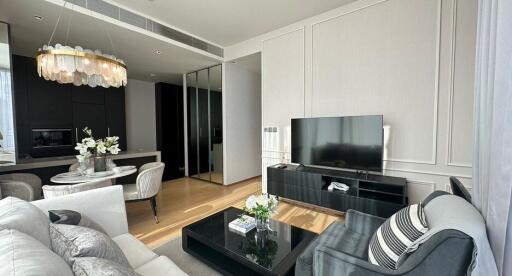 Modern living room with black furnishings and a contemporary chandelier