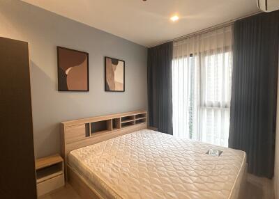 Modern bedroom with a large bed, abstract wall art, and natural light