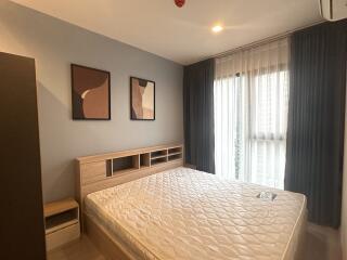 Modern bedroom with a large bed, abstract wall art, and natural light