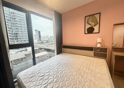 Modern bedroom with large window and a view of the city