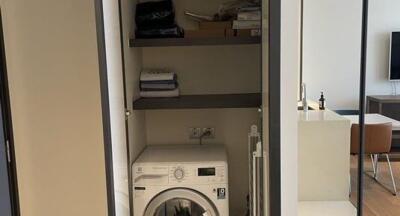 Laundry area with washing machine and storage shelves