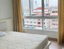 Bedroom with large window and city view