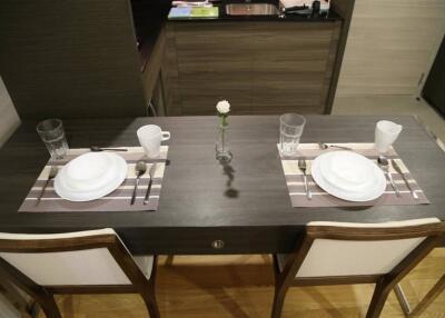 Dining table set for two with white dishes and glasses