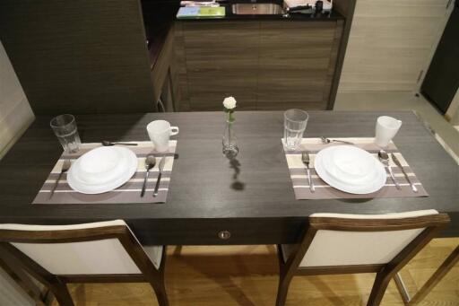 Dining table set for two with white dishes and glasses