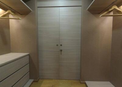 Walk-in closet with wooden shelving and drawers