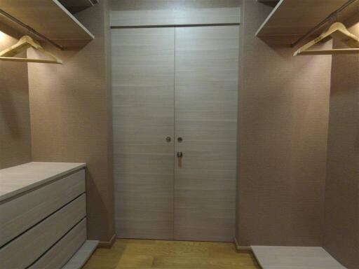 Walk-in closet with wooden shelving and drawers