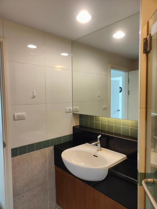 Modern bathroom sink with large mirror and elegant lighting