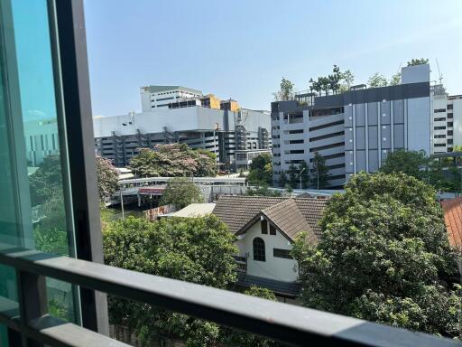 View from a building window showing a cityscape with various buildings and trees