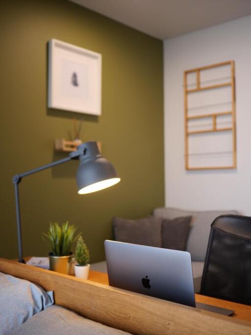 Modern home office with desk, laptop, lamp, and minimalistic decor