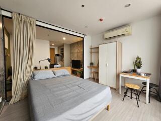 Modern bedroom with a double bed, desk, and open space to the living area