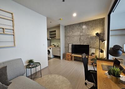 Modern living area with workspace and kitchen