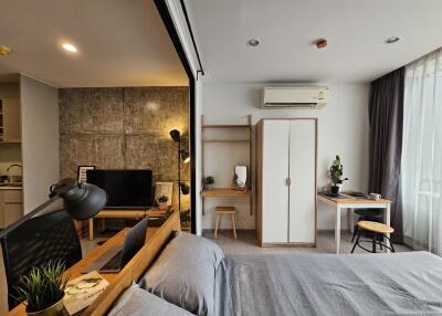 Modern multifunctional bedroom with study nook, wardrobe, and kitchenette