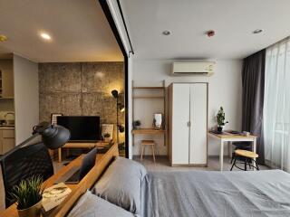 Modern multifunctional bedroom with study nook, wardrobe, and kitchenette