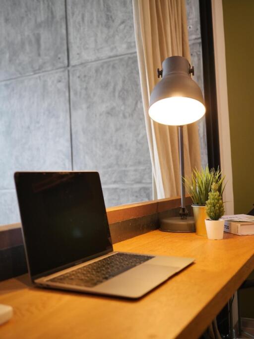 Modern home office setup with laptop and lamp