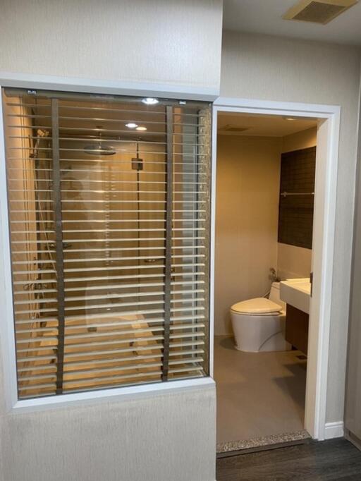 Modern bathroom featuring a glass shower door and a sleek mounted toilet.