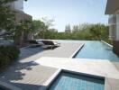 Outdoor pool area with lounge chairs and trees