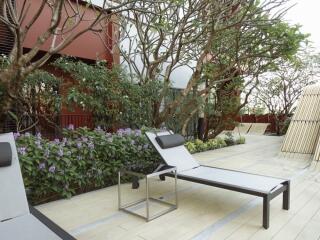 Outdoor patio area with lounge chairs and greenery