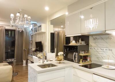 Modern kitchen with chandelier and open living area