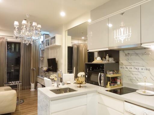 Modern kitchen with chandelier and open living area