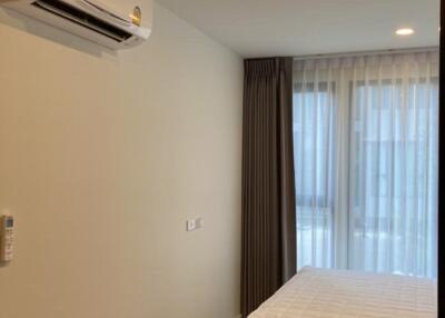 Bedroom with bed, air conditioner, and window with curtains