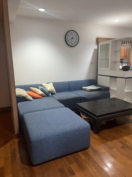 Cozy living room with blue sectional sofa and dark wooden coffee table