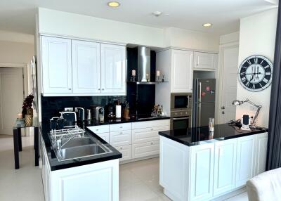 Modern white kitchen with black countertops and stainless steel appliances