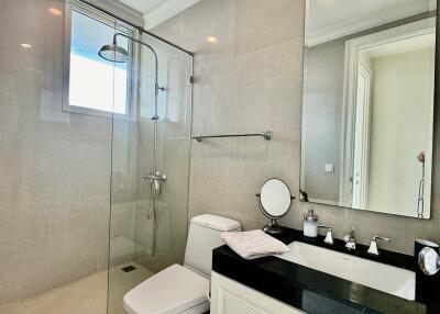 Modern bathroom with glass shower, vanity, and toilet